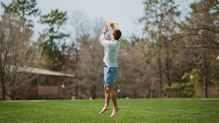 Student playing frisbee on Commons Lawn