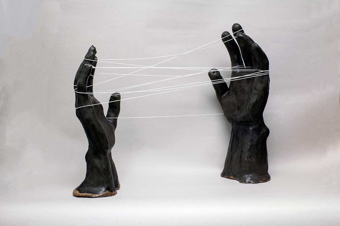 The Space Between Us - Strings intertwining between two hands