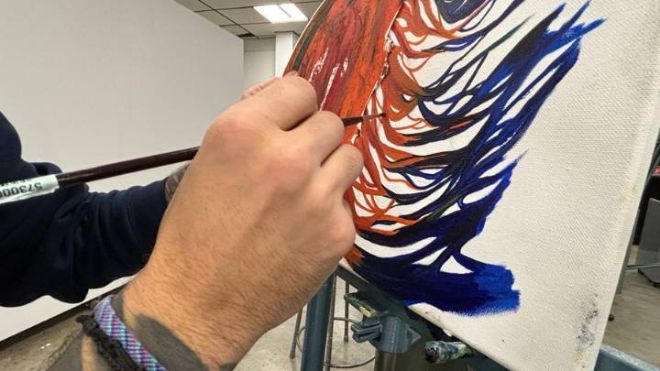 Ivan Longoria painting for one of his classes at Calvin University.